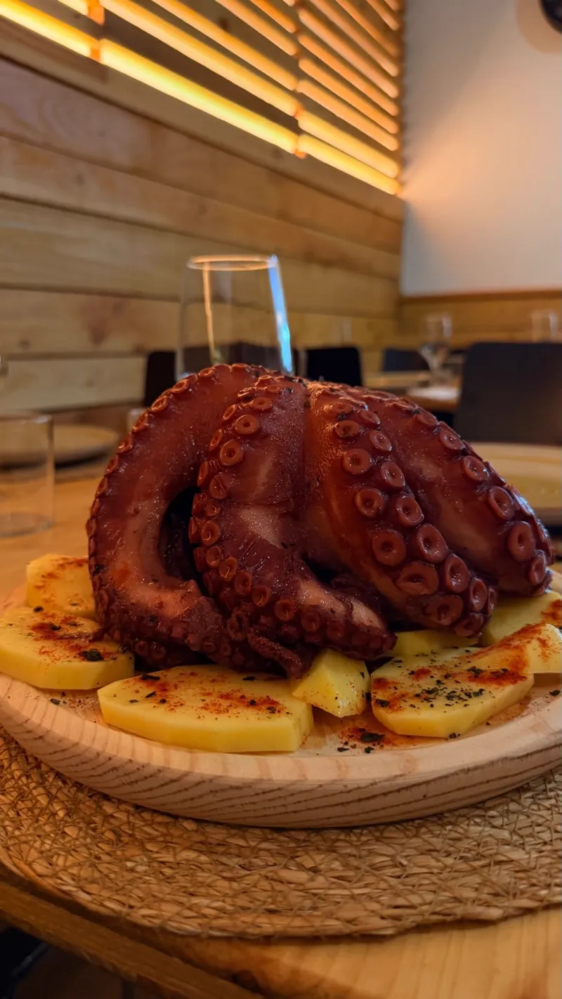 Pulpo entero con patatas al horno recién servido